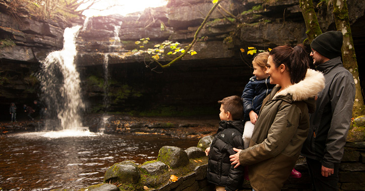 Family looking at waterfall inside Gibson's Cave